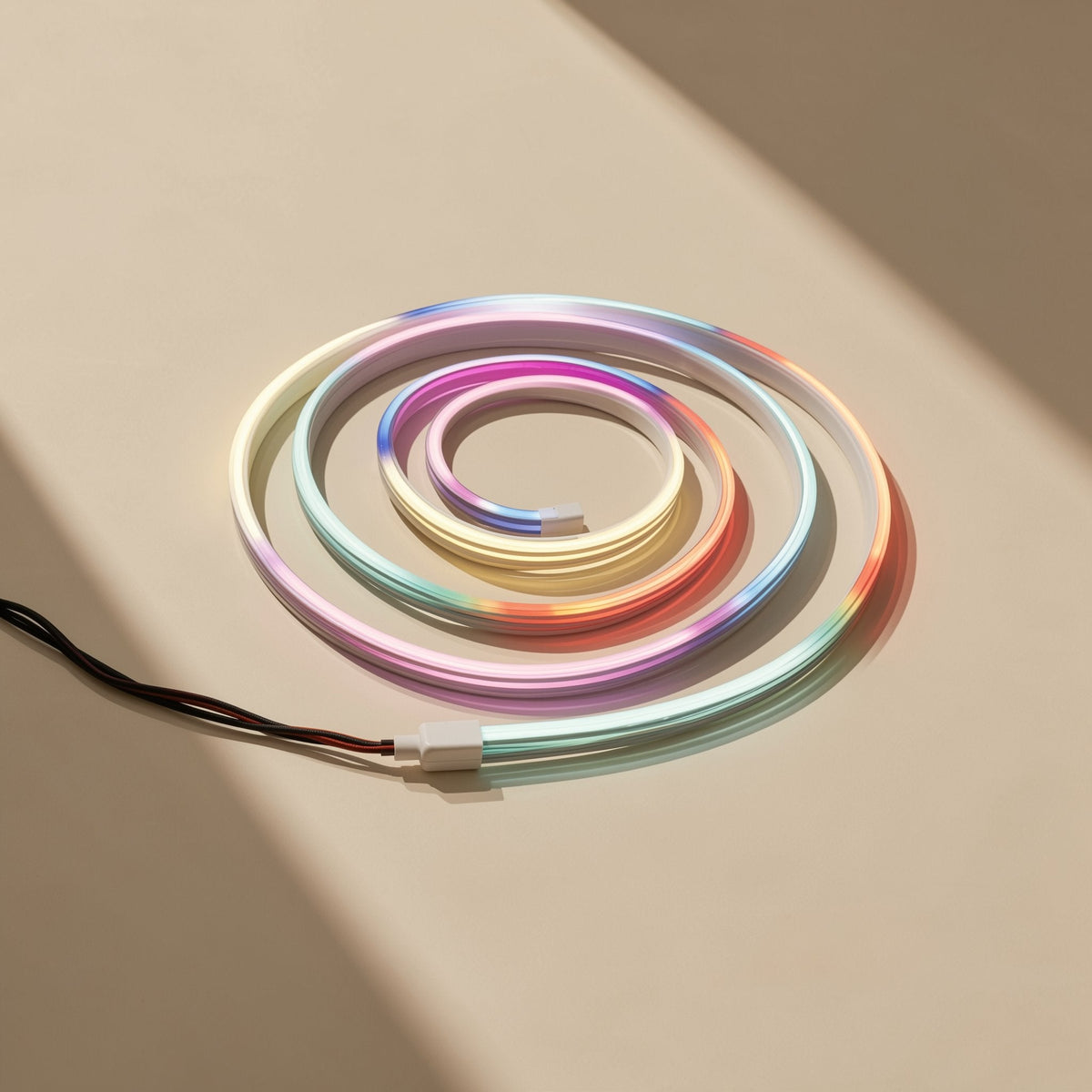 Neonflex strip coiled in a spiral, lit in rainbow gradients, with a white connector and black wire