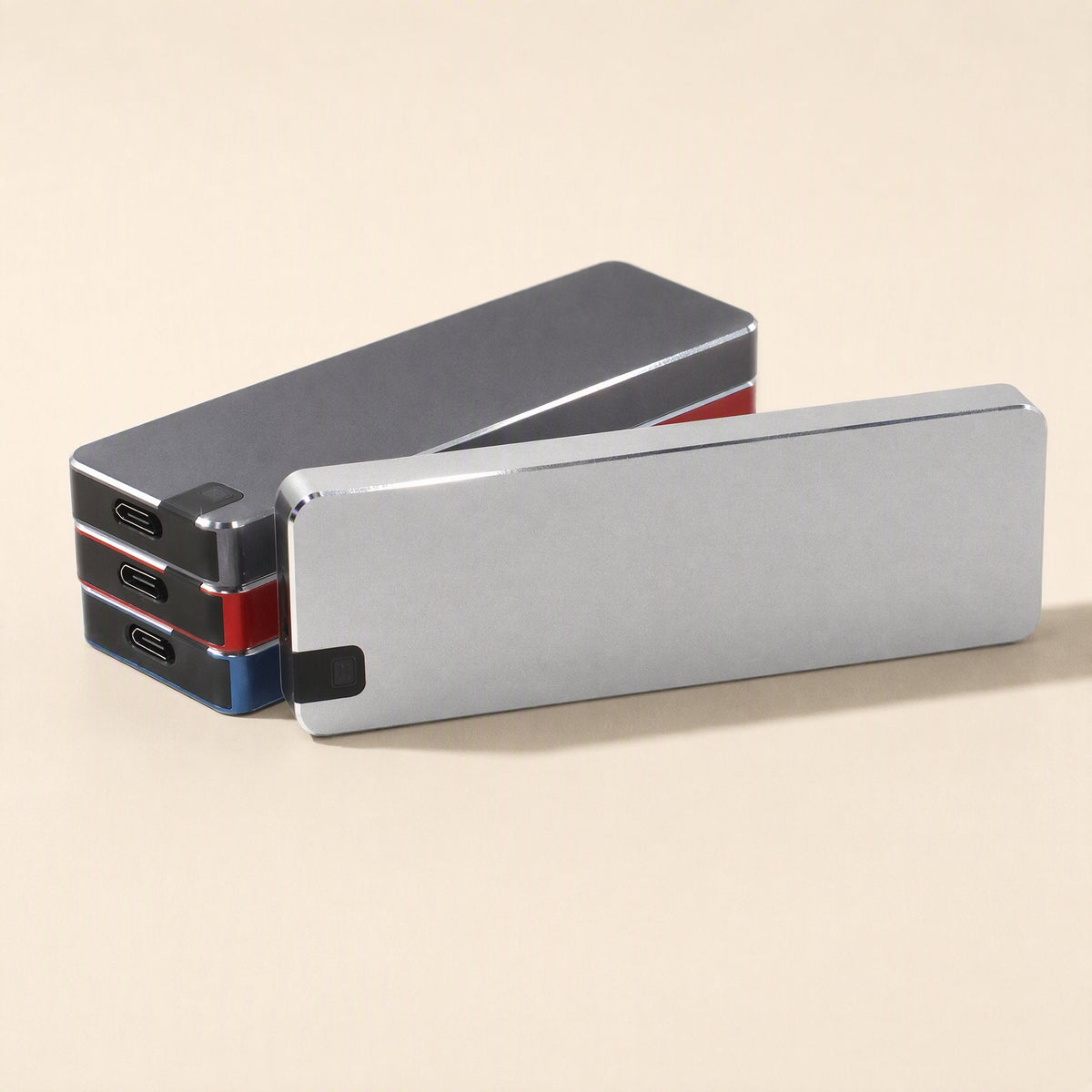 Steeldrive – Silver drive leaning against a stack of gray, red and blue drives, USB-C ports visible on the ends