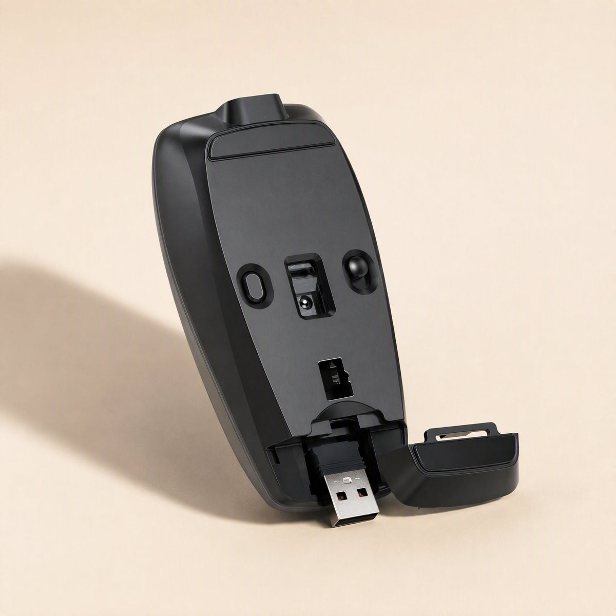 Clickmate – Underside of a black mouse with the USB receiver pulled out from its compartment and cover open