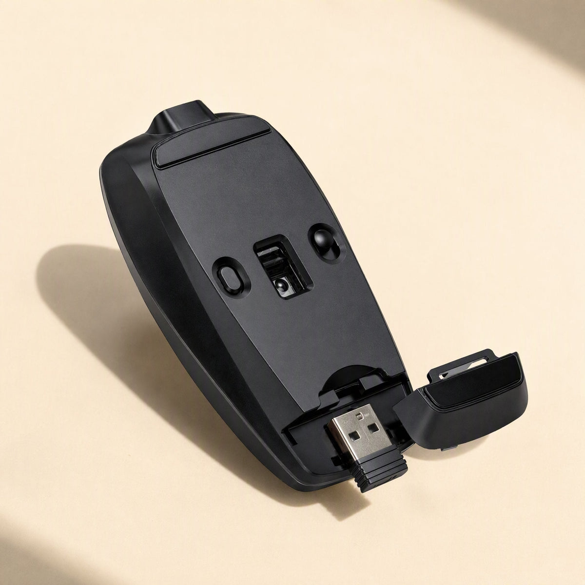 Clickmate – Mouse flipped over, showing the open battery cover and USB receiver stored in the base compartment