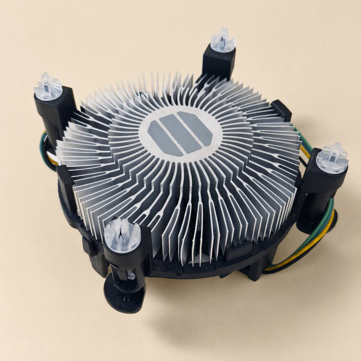 Chipbreeze – Underside angle of the circular aluminum fin heatsink with grey thermal pad and four mounting pins