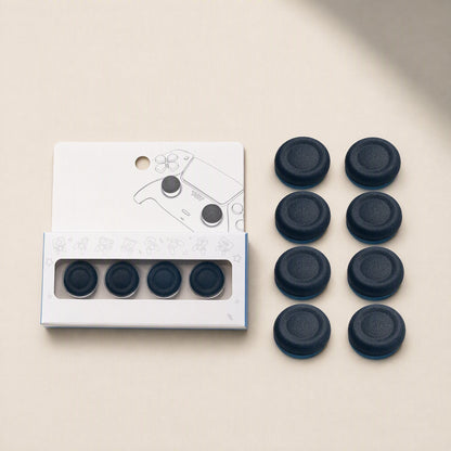 Stickgrip PS5 Aluminum Controller Stick Caps in retail packaging beside eight loose dark blue grip caps