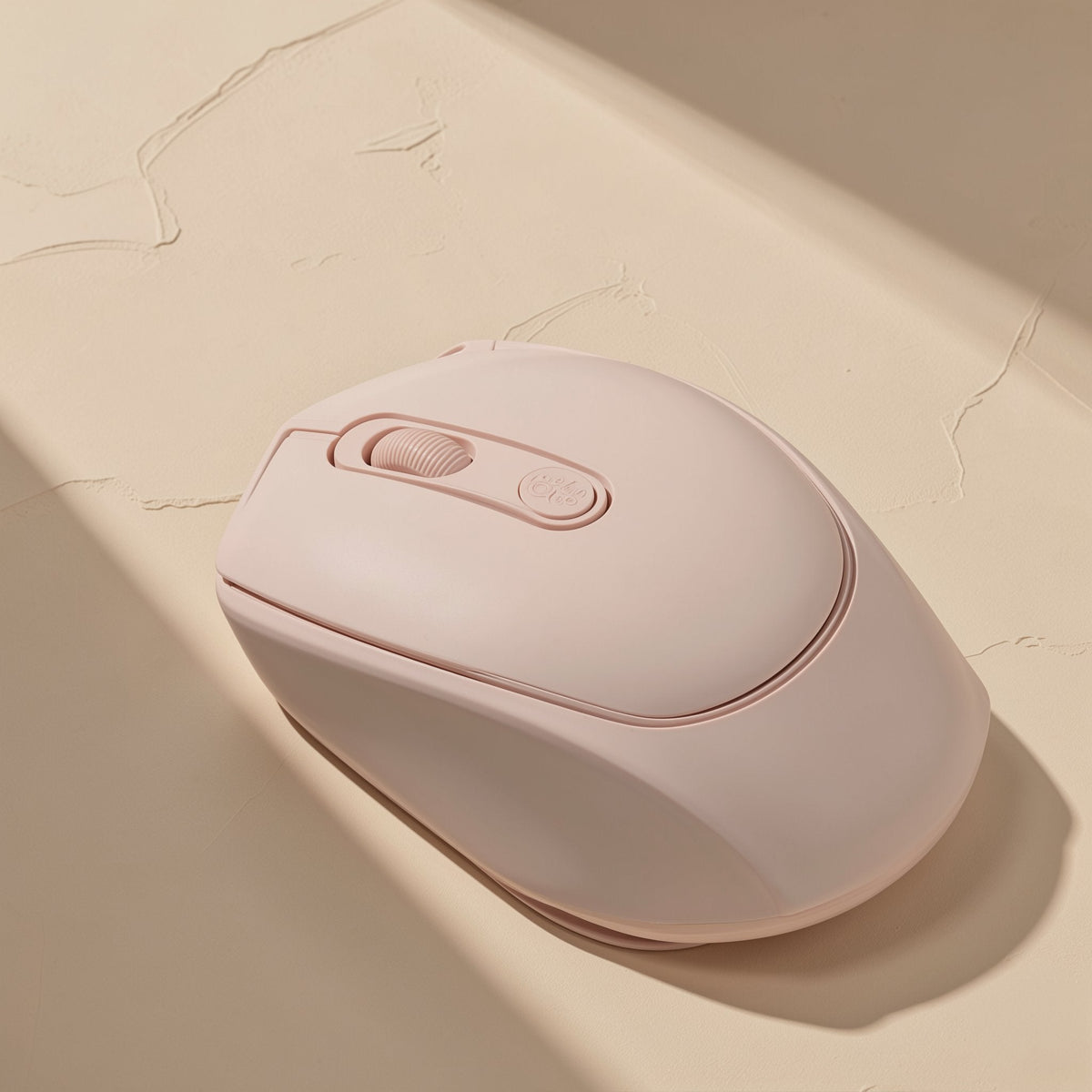 Modeglide Wireless Bluetooth Dual-Mode Mouse in blush pink, seen from above on a cream surface