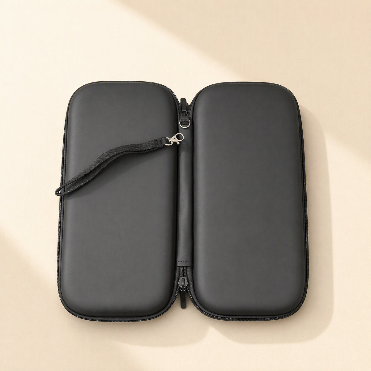 Switchstow – Black hard shell case opened flat with zipper undone and a wrist strap attached to the metal clip