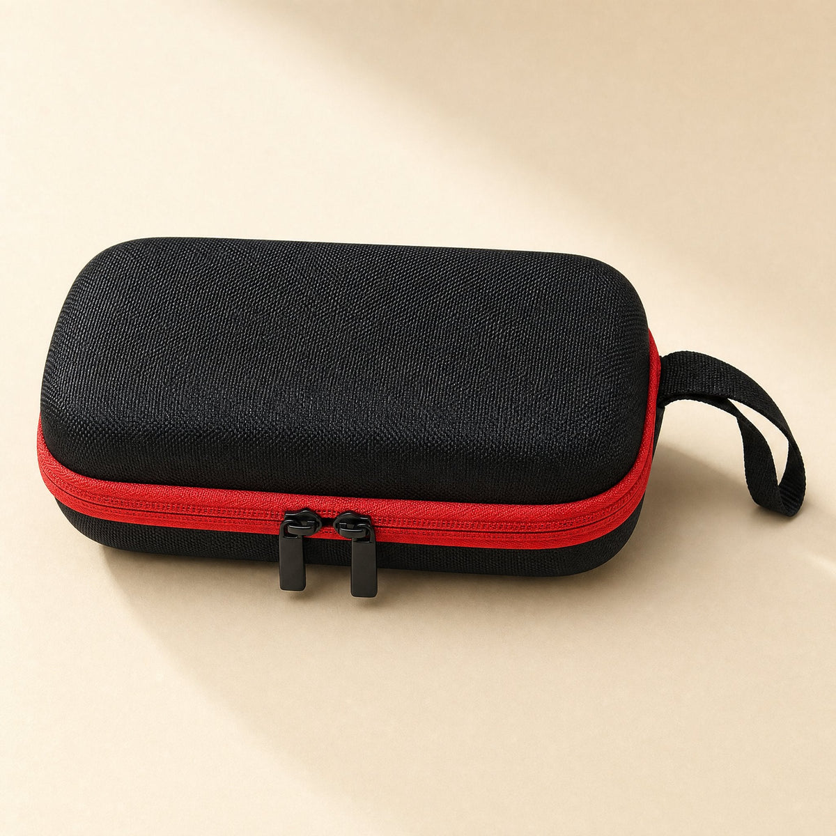 Padpouch – Close-up of the double zipper pulls and wrist loop on the black case with red zipper tape
