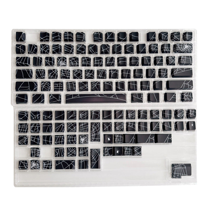 Loomwire – Black spider web keycaps laid out in clear plastic trays, showing the full 130-key set unmounted