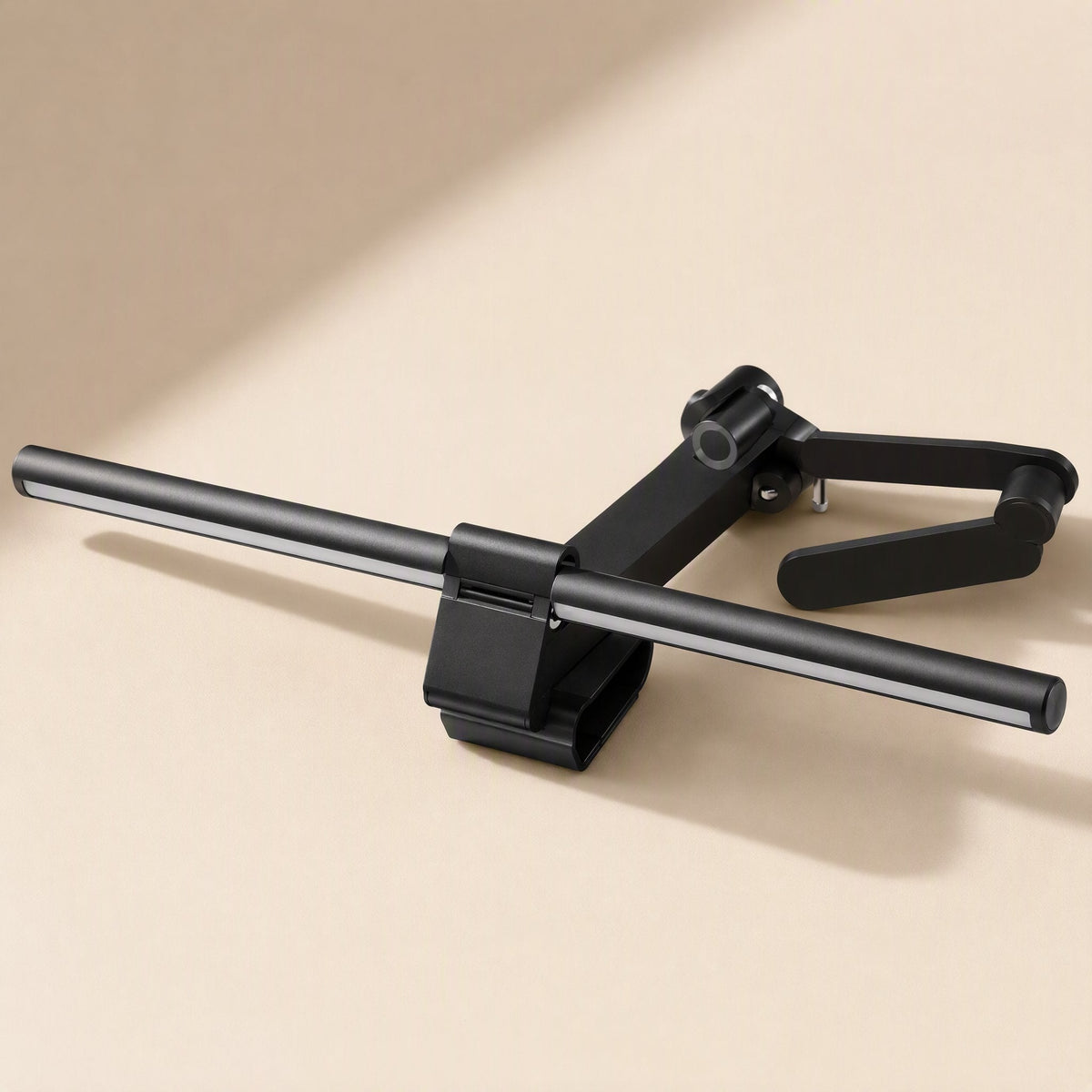 Hangglow – Lamp bar resting on its side with the counterweight arm and clip open, shown from above on a cream surface