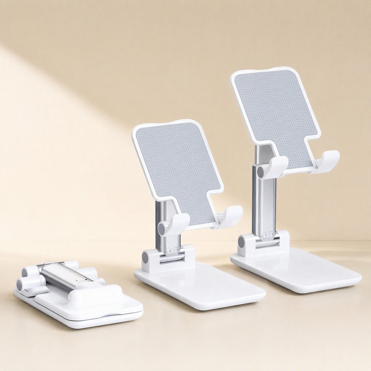 Foldangle Adjustable Folding Plastic Phone Stand shown open twice and folded flat, in white on a beige backdrop