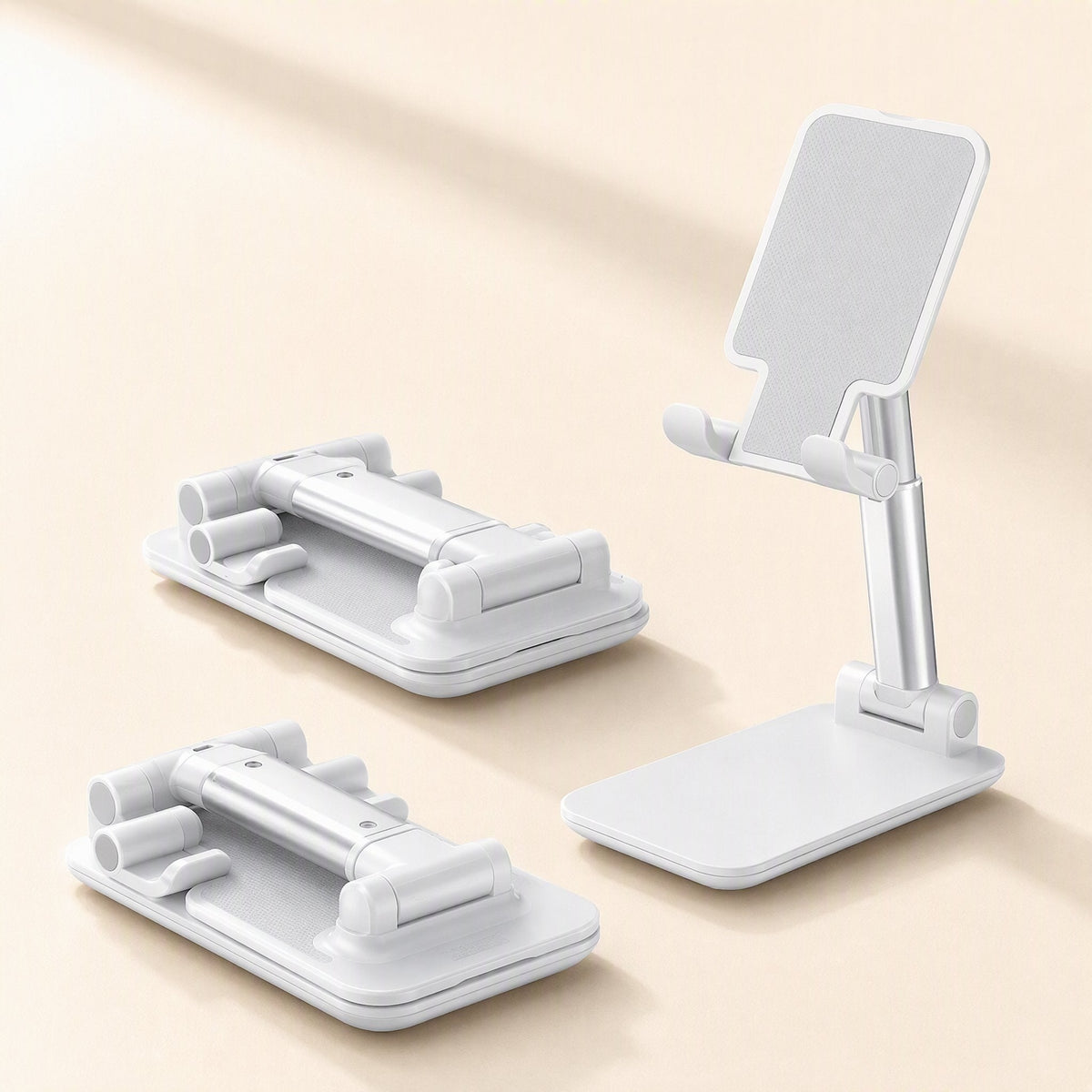 Foldangle – Two folded white stands lying flat beside one open stand with angled cradle and silver adjustable arm