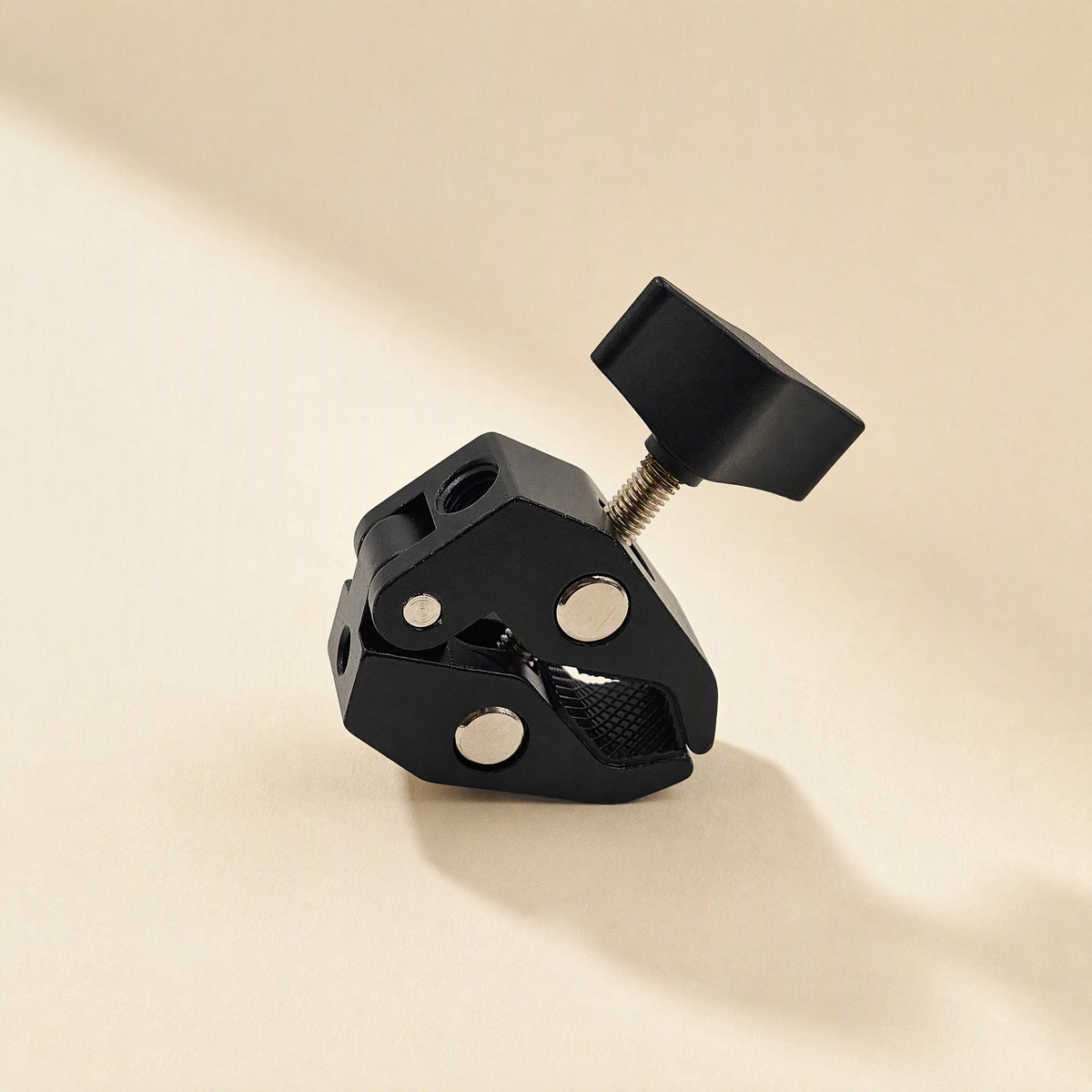 Streamclip – Black crab-claw clamp seen from the side, with threaded holes and knurled jaw pad visible