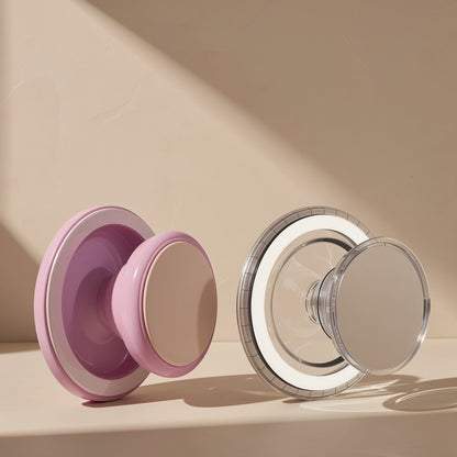 Cushgrip Magnetic Phone Airbag Holder in pink and clear versions standing side by side on a beige surface