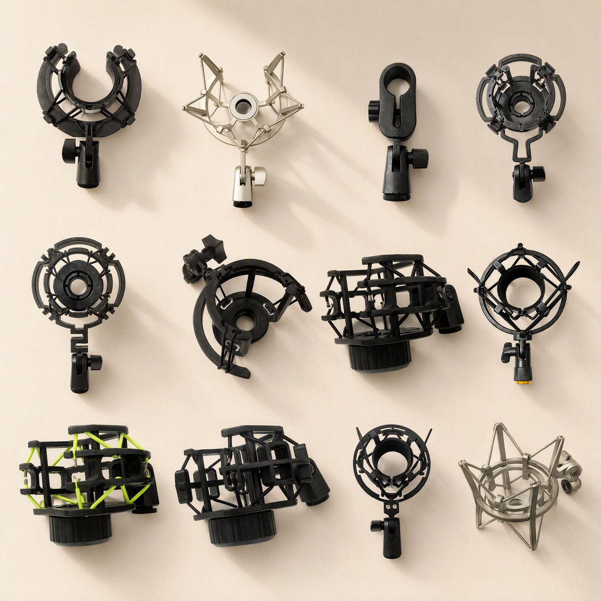 Joltclip Microphone Shock Mount Clip lineup of twelve black, silver and green-accented mounts on a beige background