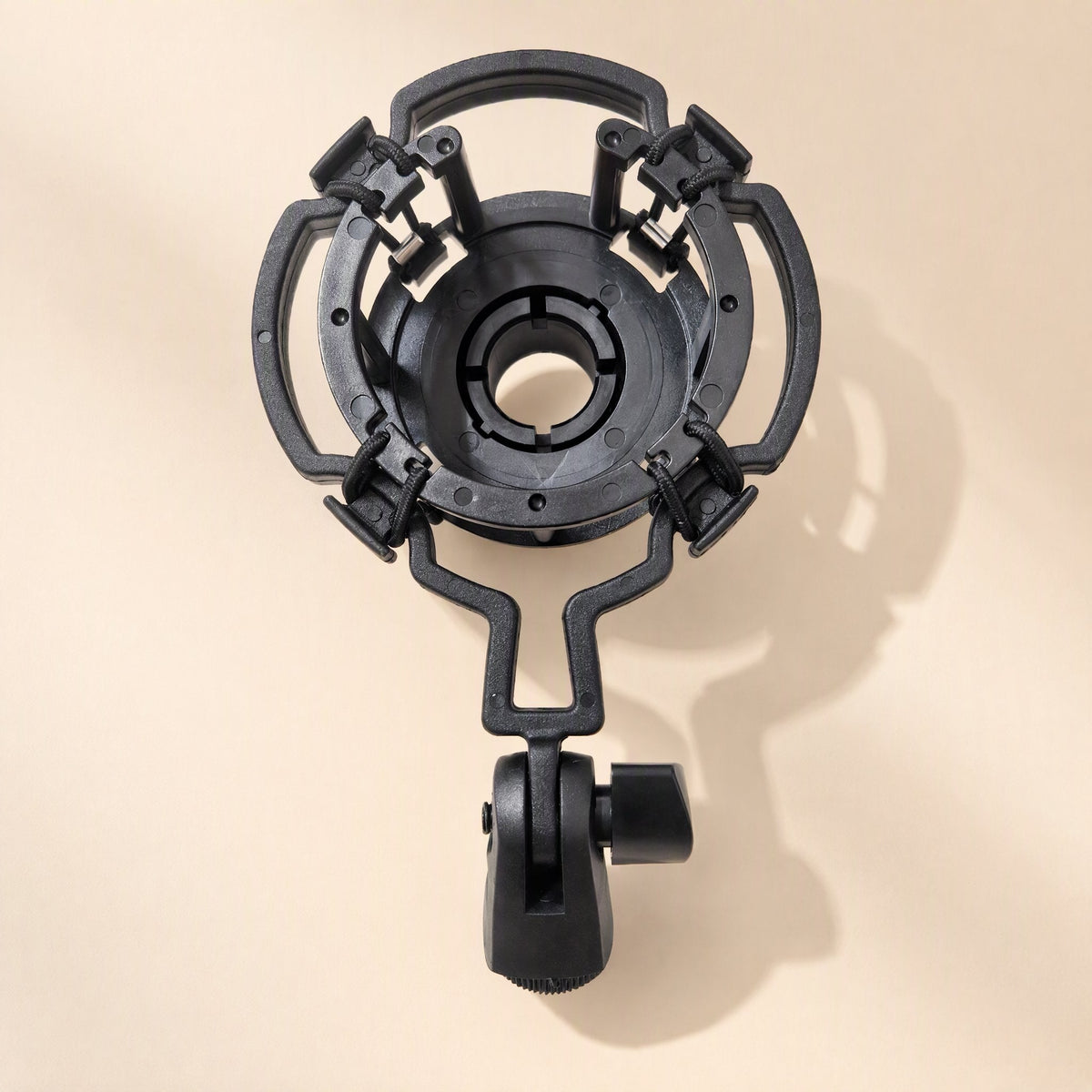Joltclip – Black suspension shock mount with a round cradle, elastic-held arms and a thumbscrew stand adapter, top-down view