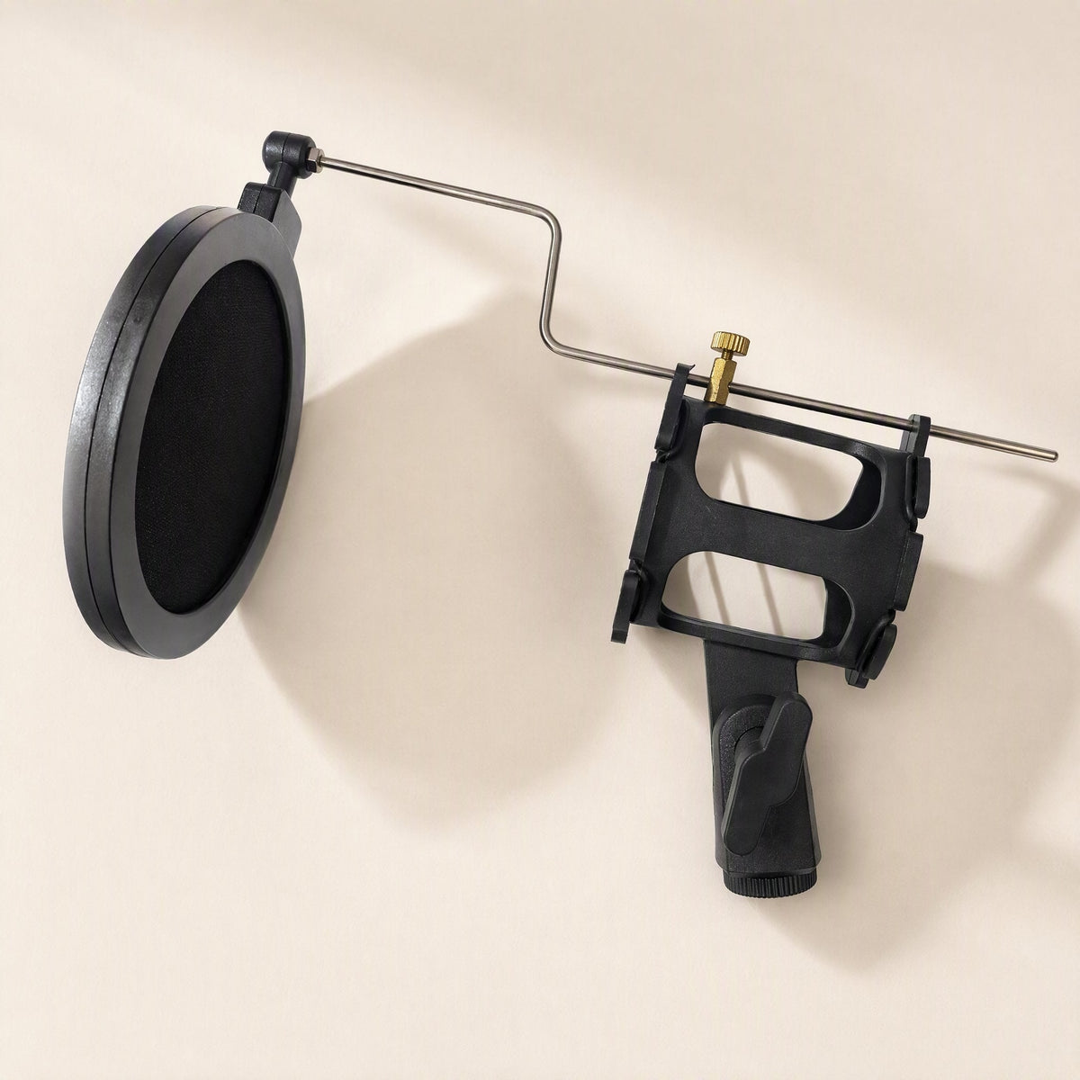Joltclip – Black shock mount cradle with a pop filter screen attached by a bent metal arm and a brass thumbscrew