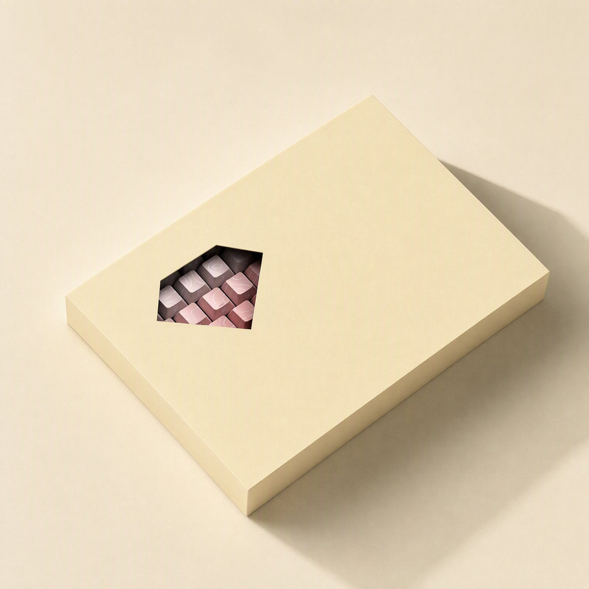 Sidescript – Cream-colored keycap box with a diamond-shaped window revealing pink and gray keycaps inside