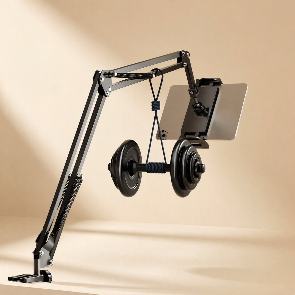 Metalhold – Black cantilever desk arm holding a tablet above a hanging dumbbell, showing the spring-supported arm