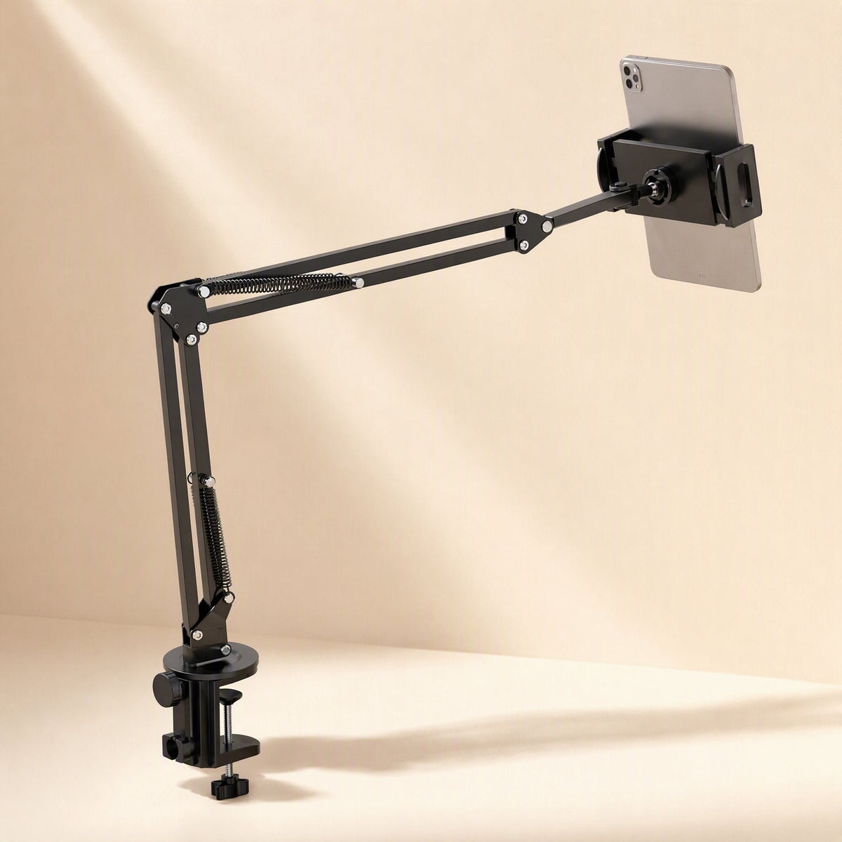 Metalhold – Desk-clamped black arm extended sideways with a tablet mounted on the cradle in portrait orientation