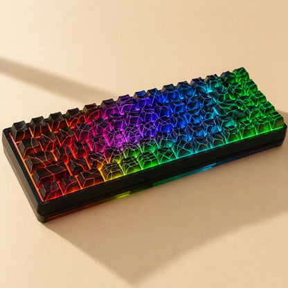 Webweave – Rainbow-lit compact keyboard fitted with black spider web keycaps, shown at a low angle