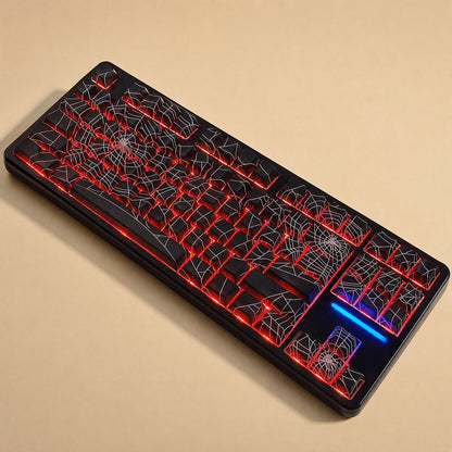Webweave – Black spider web keycaps on a full keyboard with red backlighting and a blue spacebar light