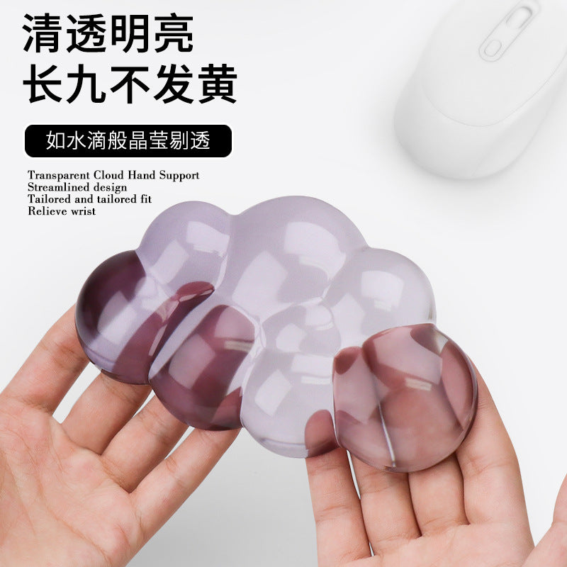 Restcloud Rubber Wrist Rest Pad – two hands holding a clear purple cloud wrist rest, with a white mouse behind it