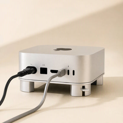 Back view of the Miniperch stand with a Mac Mini, showing power and USB-C cables plugged into the ports