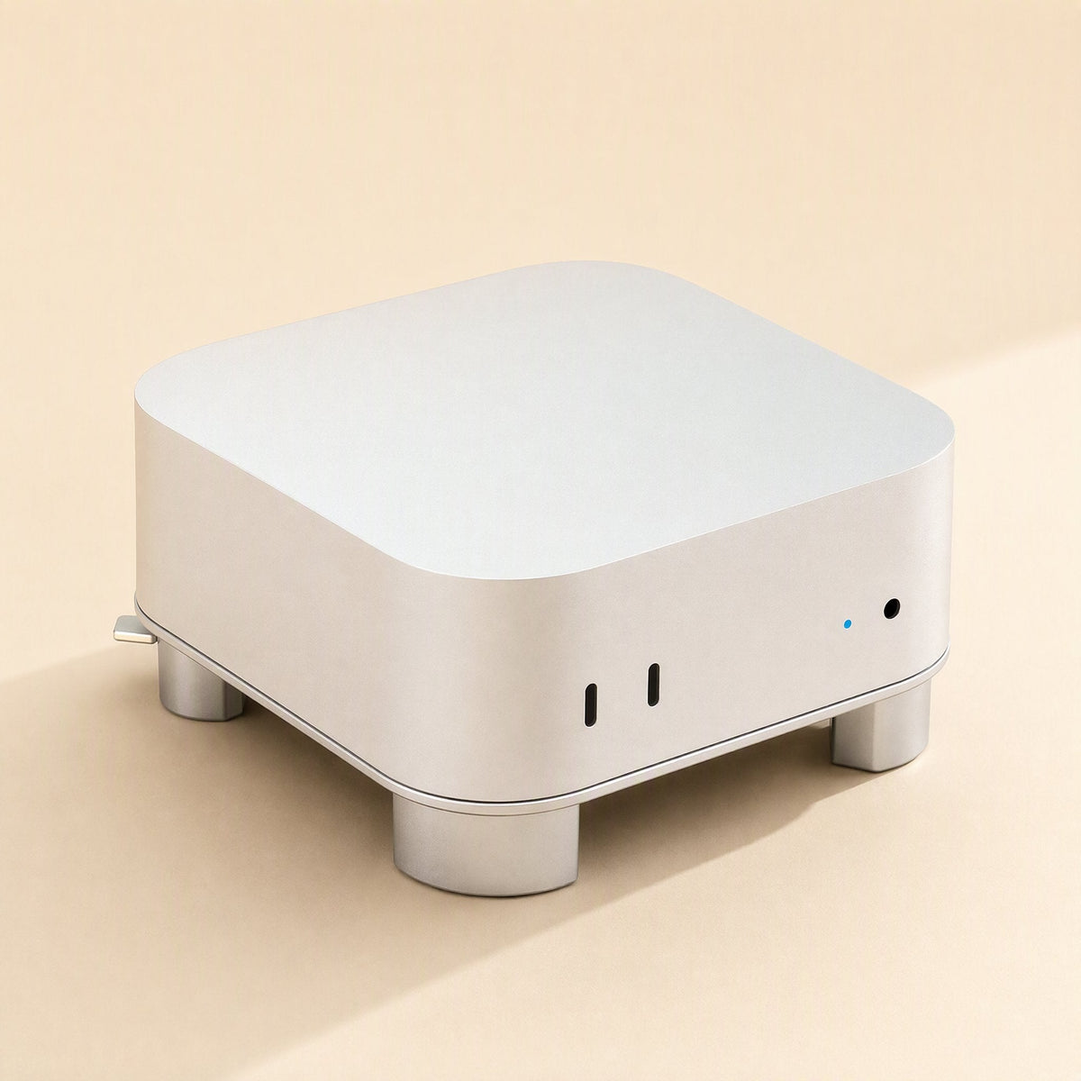 Miniperch – Front three-quarter view of a Mac Mini raised on silver aluminum feet, with USB-C ports and indicator light