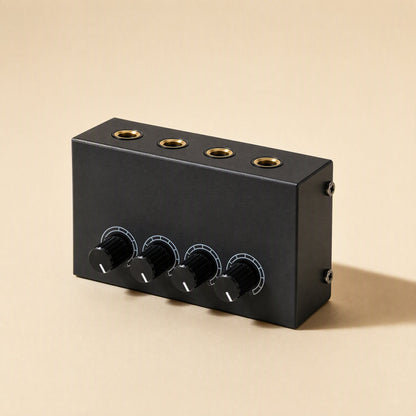 Ampwave – Black four-channel amplifier from the front left, showing gold-ringed headphone jacks on top and four knobs