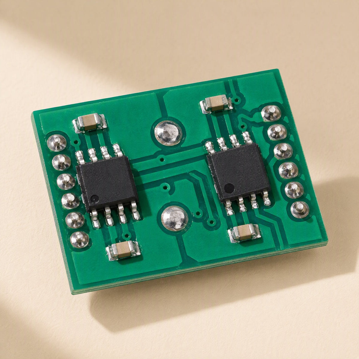 Ampwave – Top-down view of green circuit board with two black chips and rows of solder pads