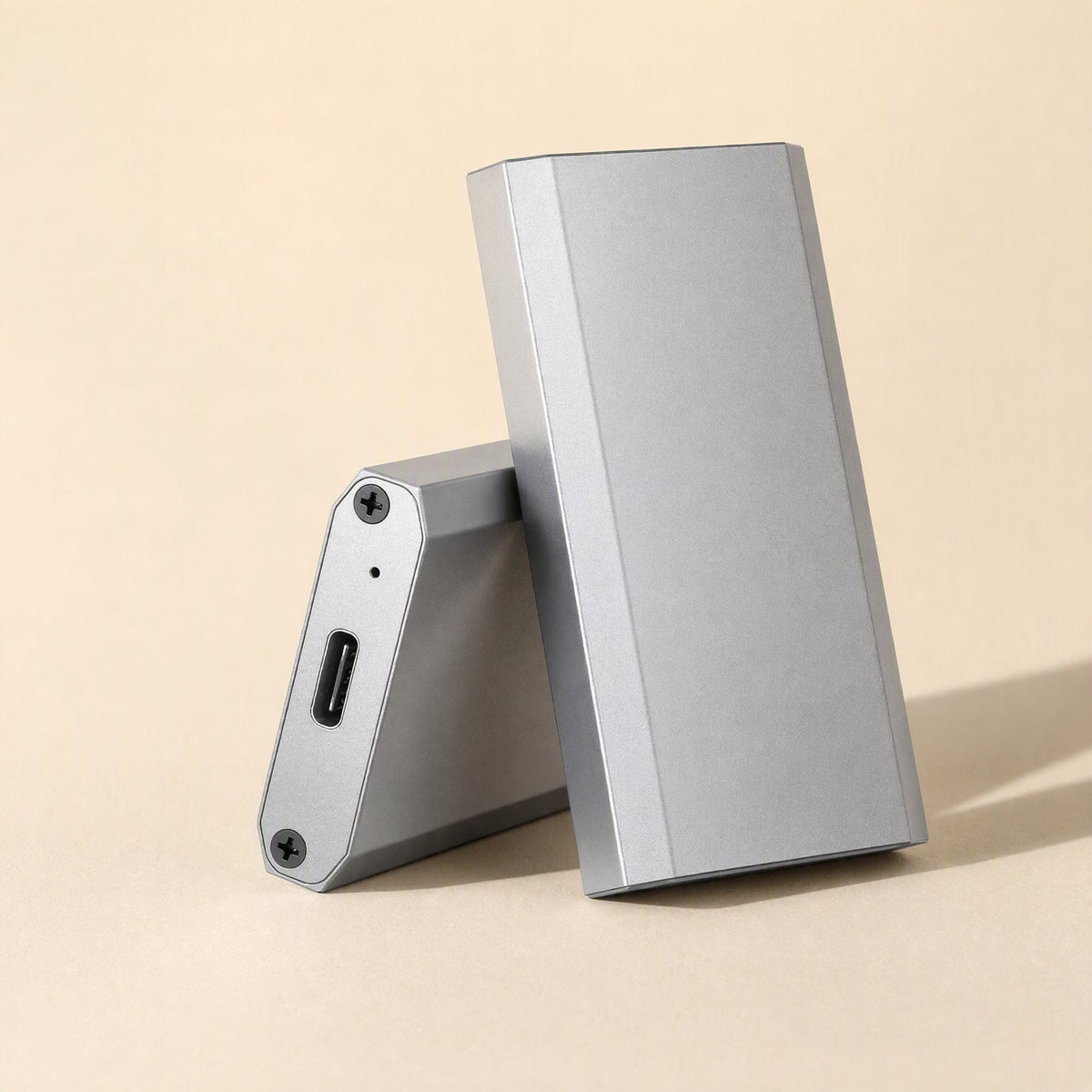 Bytehusk mSATA Solid State Drive Enclosure, silver aluminum, one unit leaning on another to show USB-C port