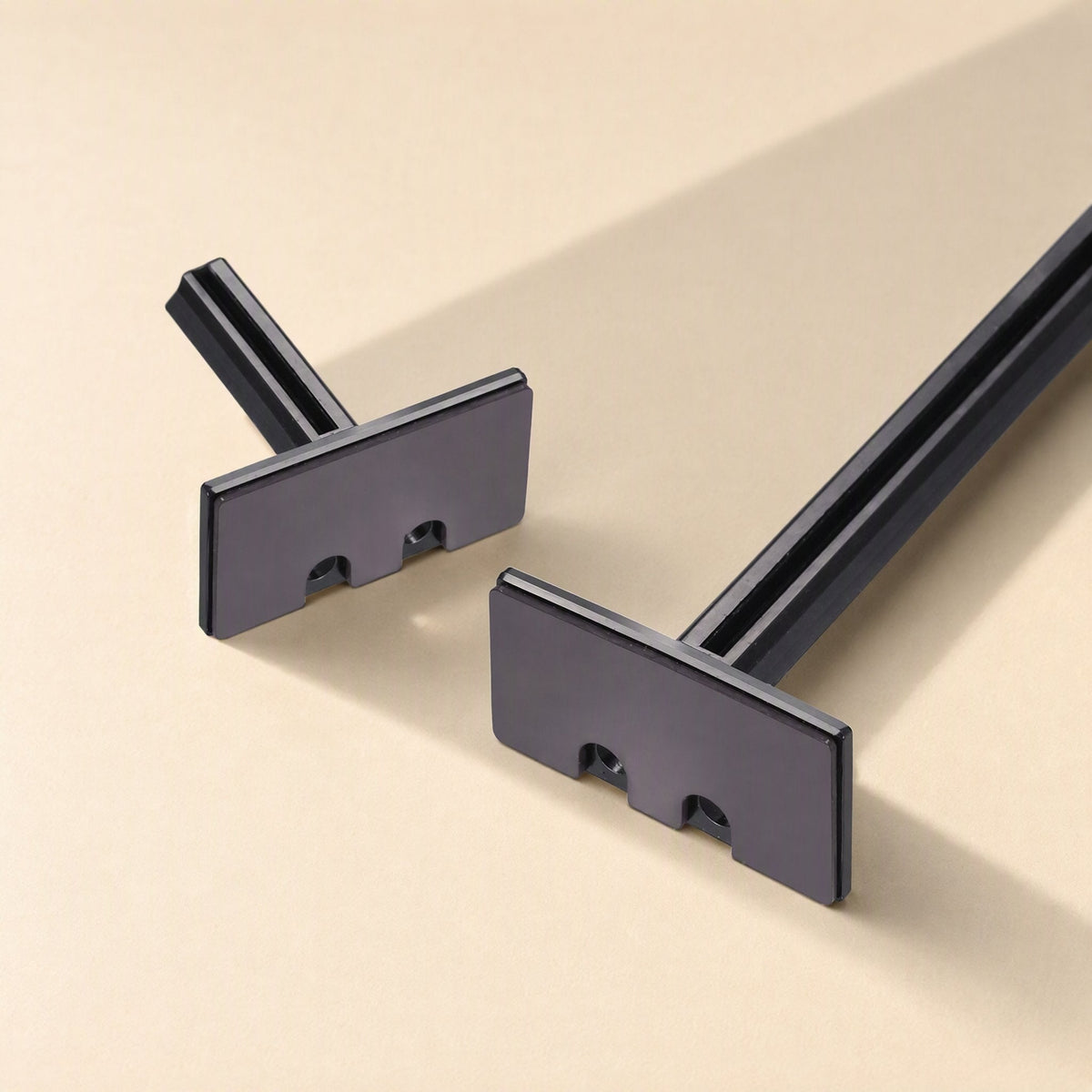 Chipstand – Close-up of two flat rectangular bracket support plates with notched edges, shown against a cream background