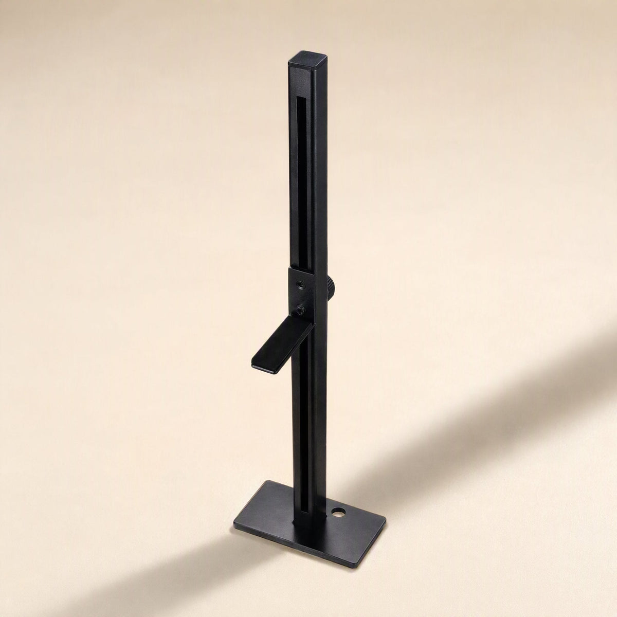 Chipstand – Black vertical bracket with adjustable arm and flat base plate with a round hole, seen from above at an angle