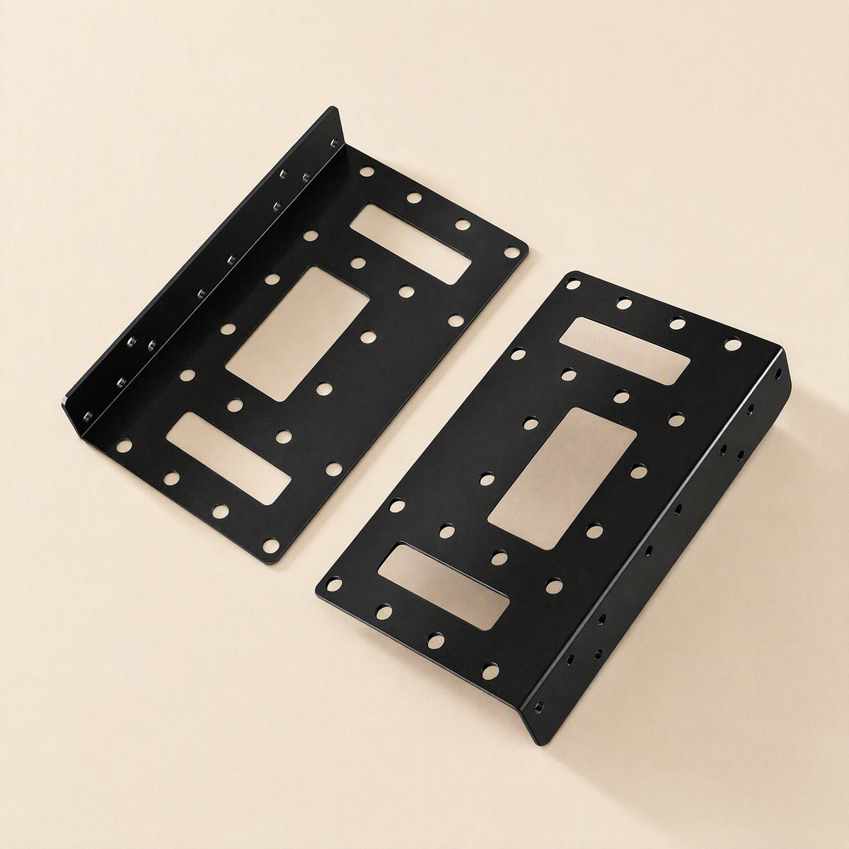 Bayrise – Two black brackets laid flat, showing perforated panels, rectangular slots, and bent side flanges