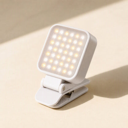 Snapshine – White square clip-on LED light with a grid of warm and cool bulbs, shown tilted on a cream surface