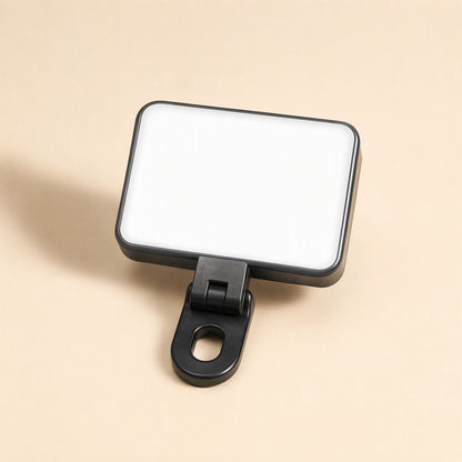 Snapshine – Black fill light with a hinged joint between the glowing white panel and the looped clip, angled view