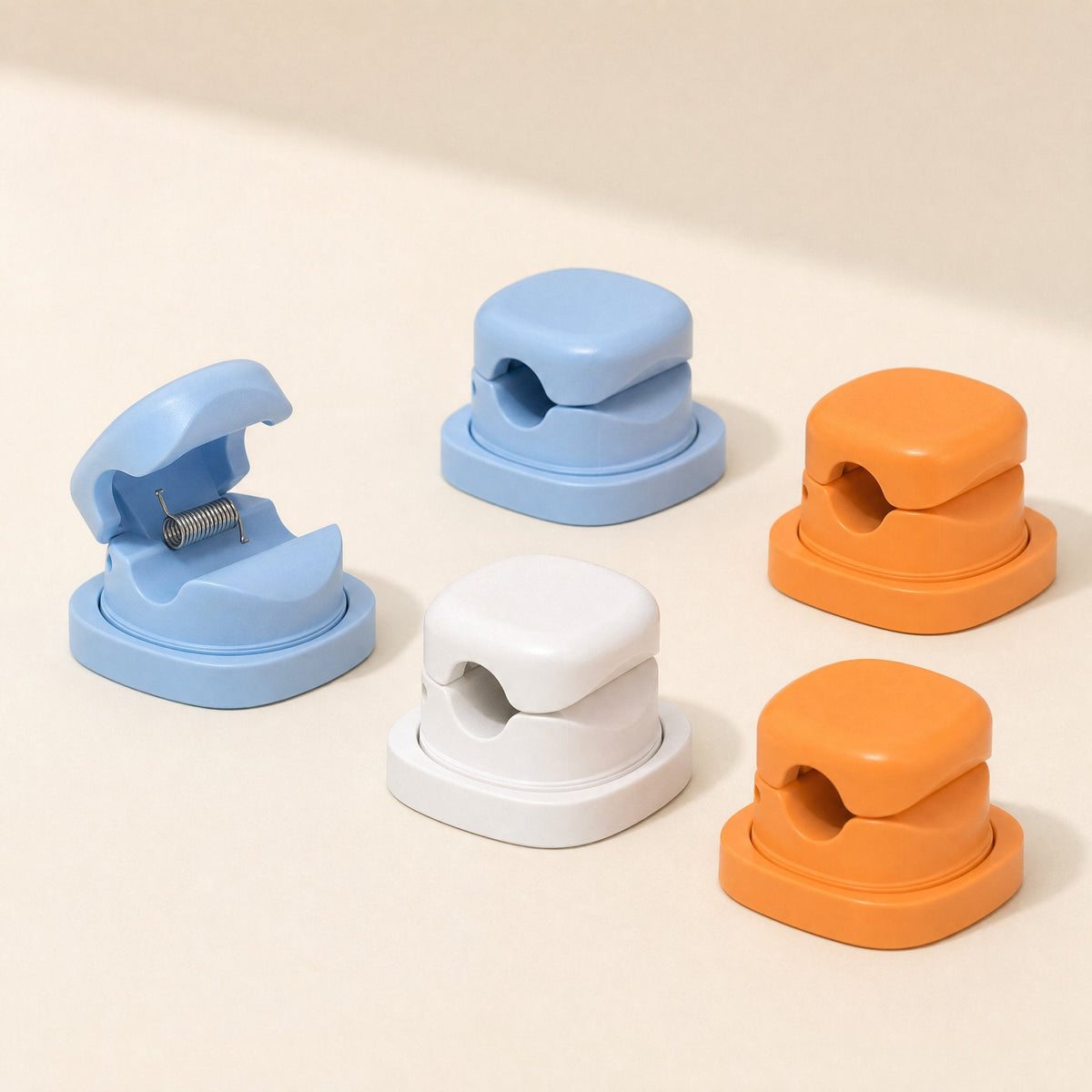 Spincoil Rotating Spring Cable Organizer in blue, white and orange, one blue clip open to show the spring