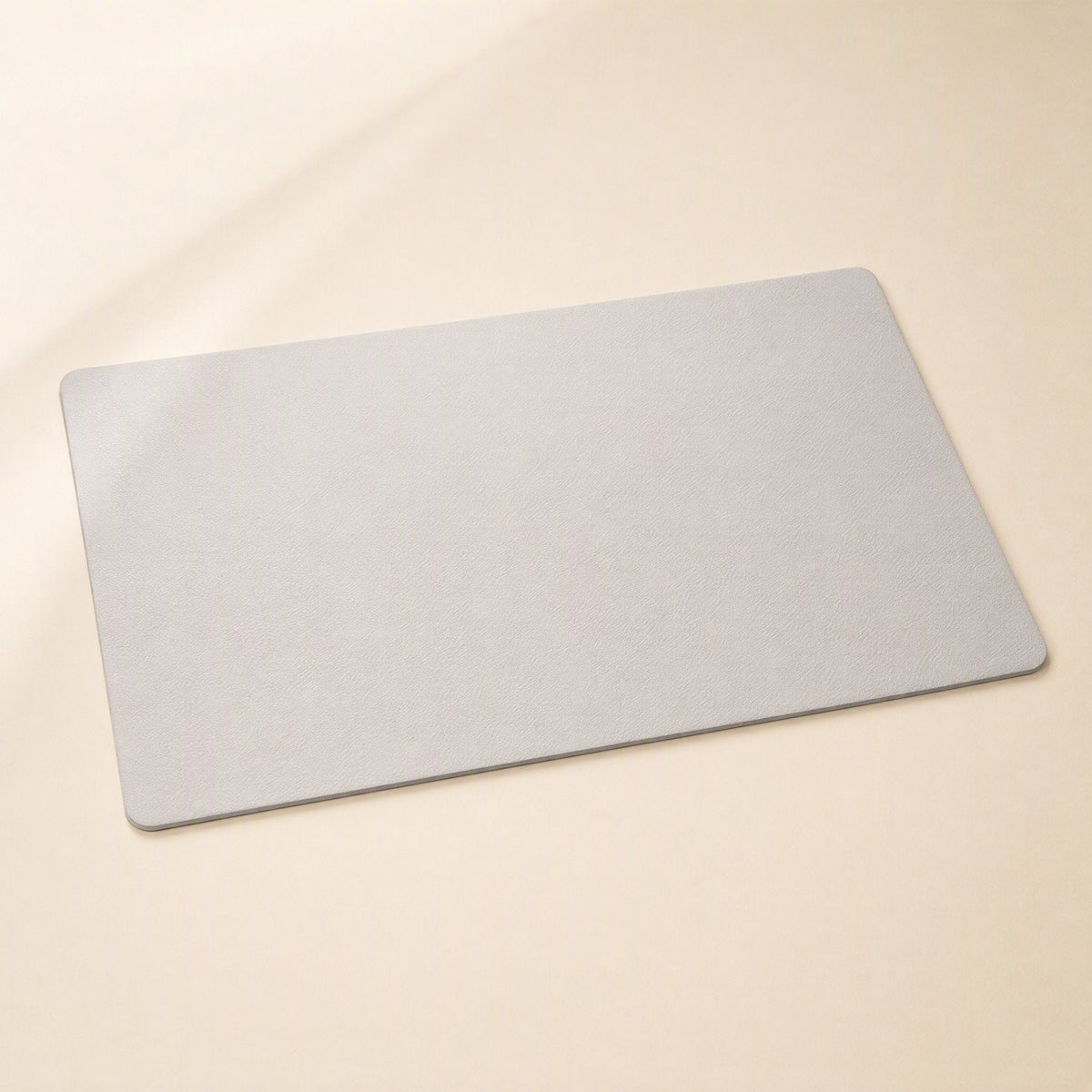 Smoothpad PU Leather Desk Mat – light grey desk mat with softly rounded corners, photographed from above at an angle