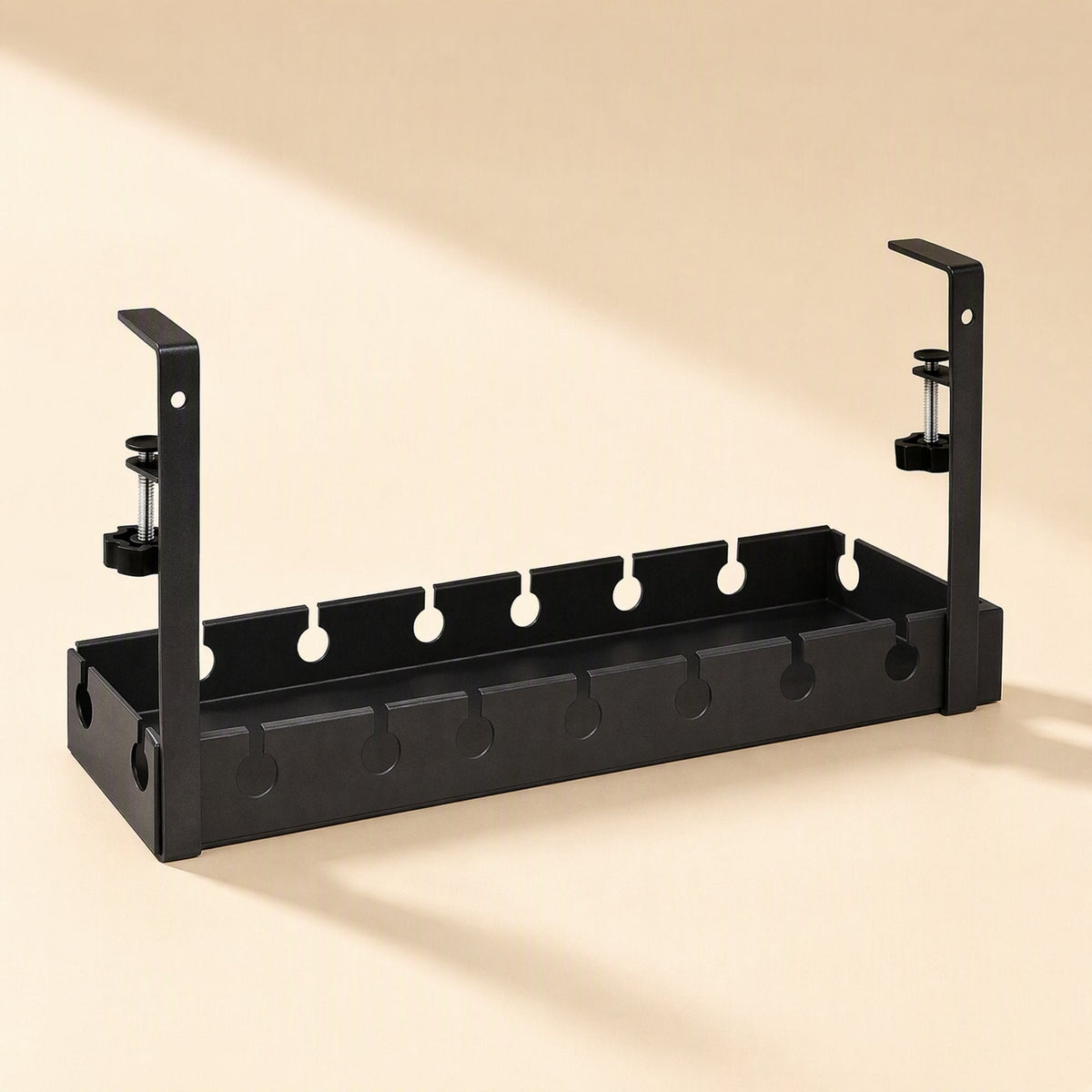 Deskspan Under-Desk Cable Management Rack in black with two clamp brackets, angled view on a cream backdrop