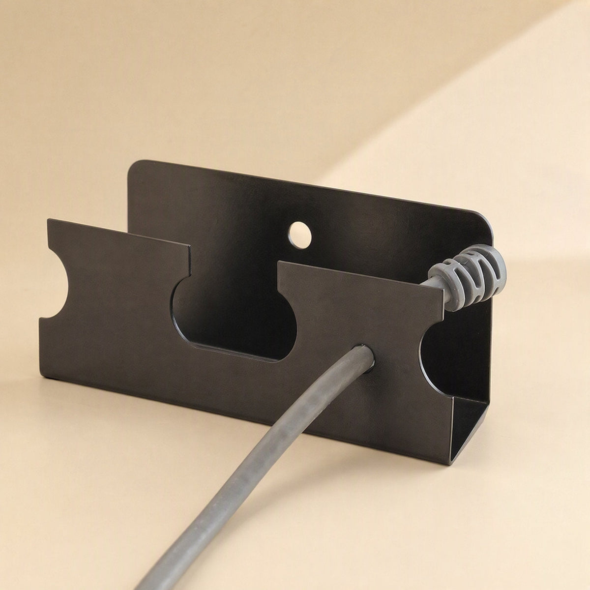 Deskspan – Close-up of the rack's end panel with a round hole, a gray cable passing through a side notch