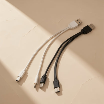 Typepair One-To-Two Type-C Charging Cable in white and black, laid flat on a beige surface in angled light