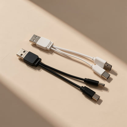 Typepair – White and black USB splitter cables with differing tips, one with a round barrel plug, on a cream backdrop