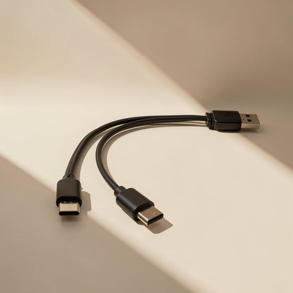 Typepair – Black cable with a USB-A end splitting into two Type-C connectors, resting on a pale sunlit surface