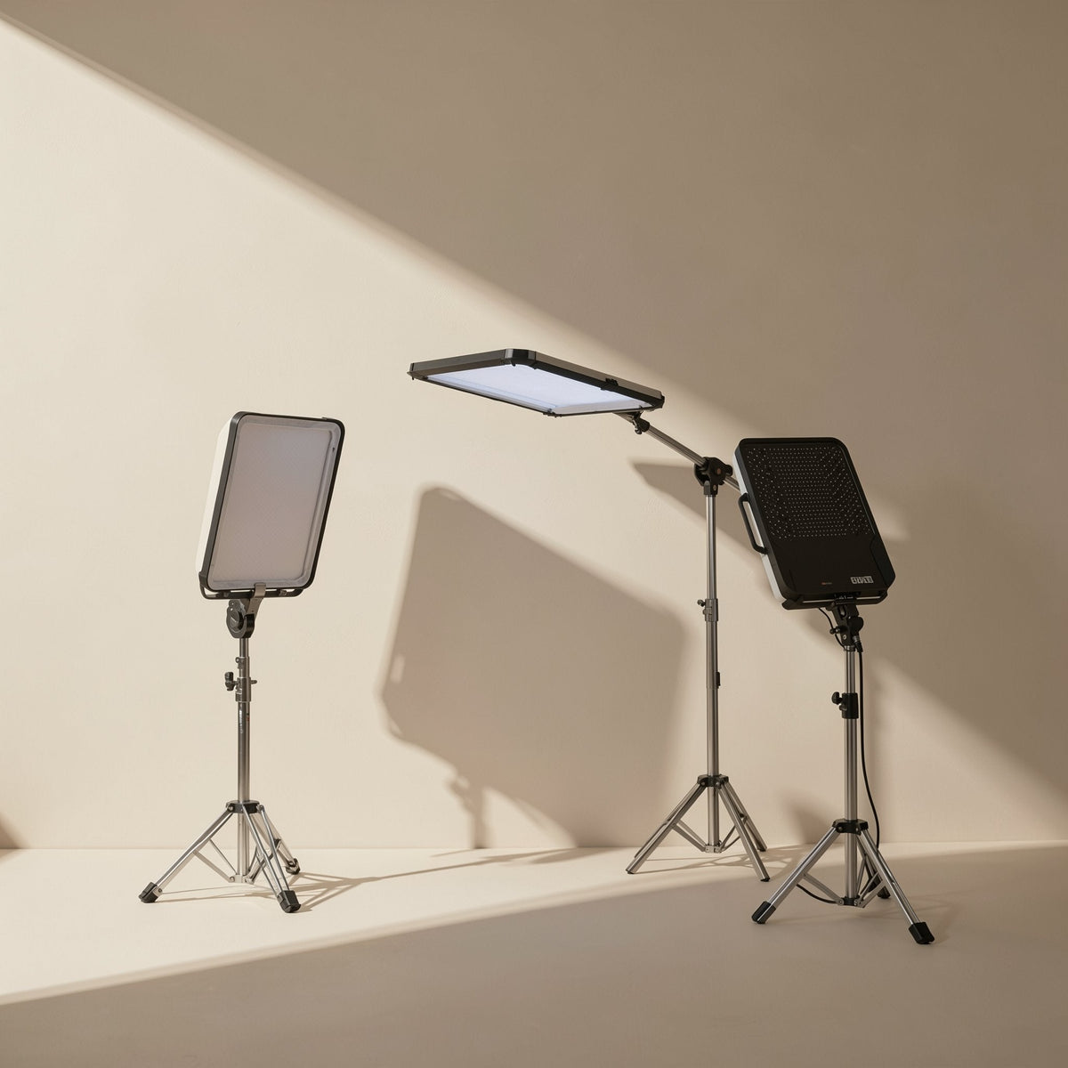 Facegleam – Three LED panels on tripod stands of different heights, one tilted flat overhead and one showing its black back