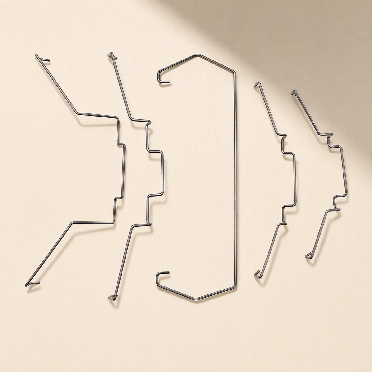 Fanclip Steel Wire CPU Radiator Fan Buckle, five metal clips laid out flat on a cream background