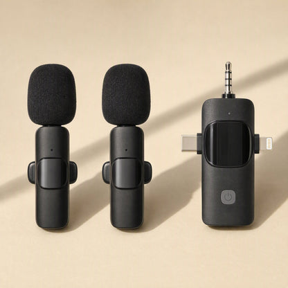 Voiceclip – Two black clip-on mics with foam windscreens next to a receiver with 3.5mm, USB-C and Lightning plugs