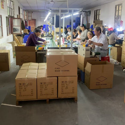 Clicken – Workers assembling and packing mice at long tables in a factory, with cartons marked Made in China in front