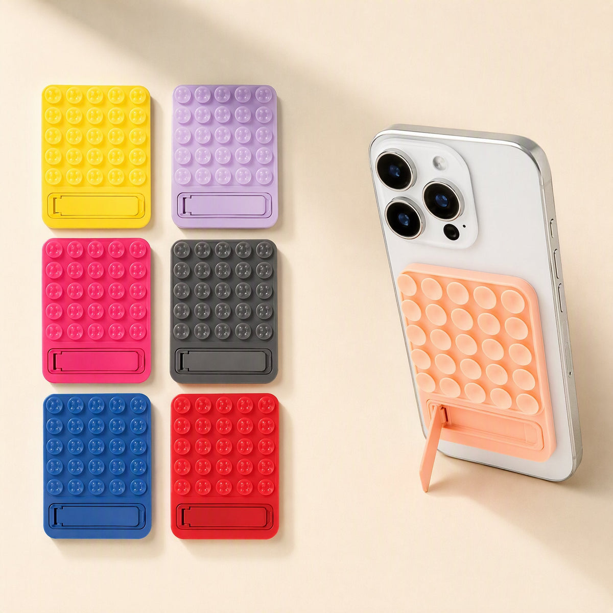 Suctionstay Silicone Suction Cup Phone Holder in six bold colours beside a phone with an orange holder attached