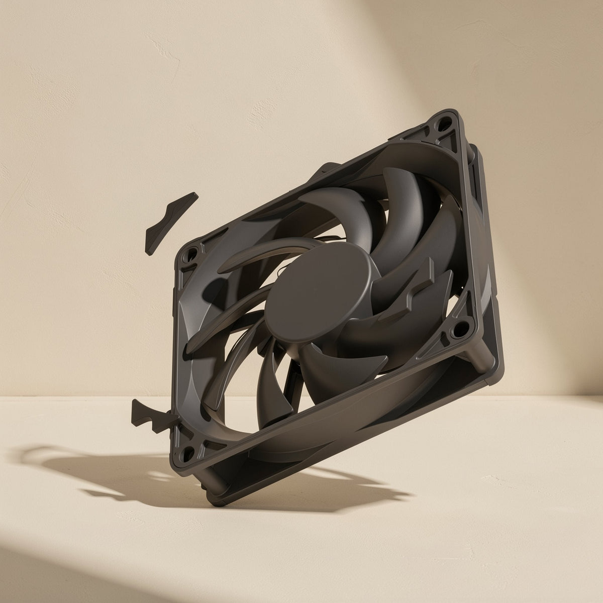 Airspin – Black fan floating at a tilt with two small detached parts beside it, against a cream wall