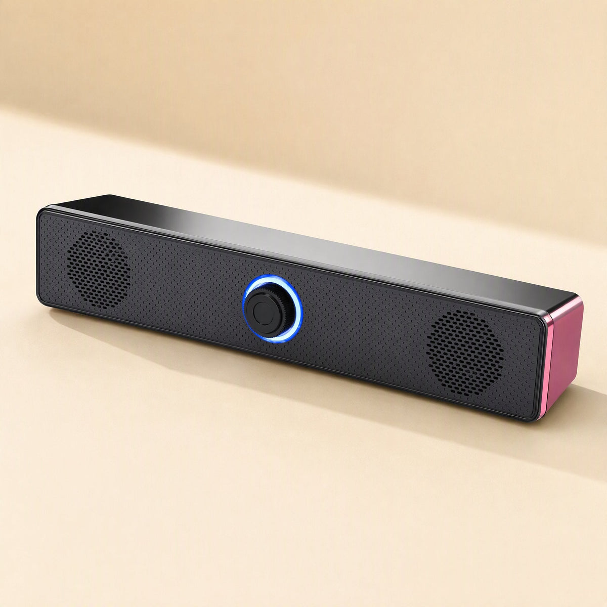 Soundbit USB Mini Computer Speaker, black soundbar with pink end cap and glowing blue ring knob, angled view