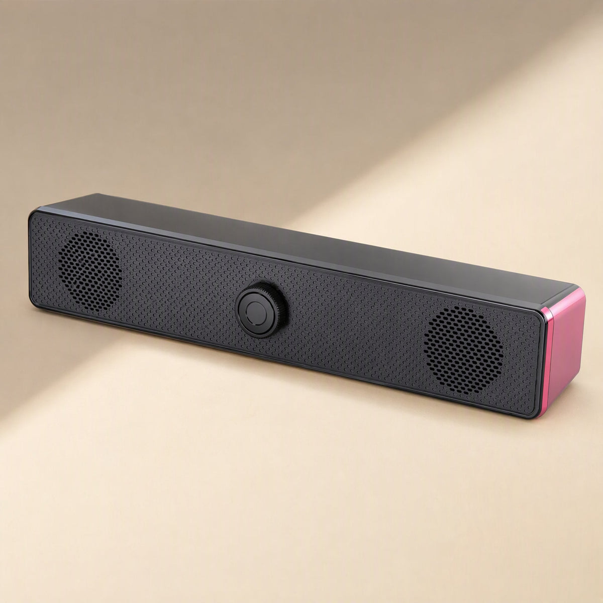 Soundbit – Black soundbar speaker with pink side panel and an unlit center knob, angled on a cream background