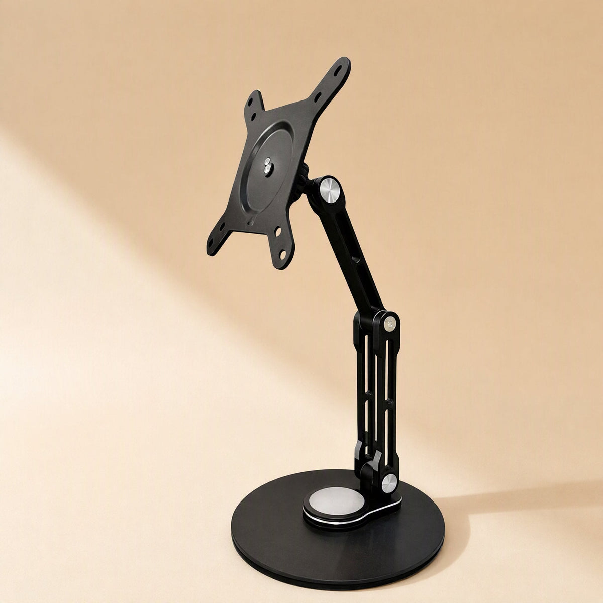 Swiveldesk – Black monitor stand with round base and VESA mounting plate, shown from the front on a beige background
